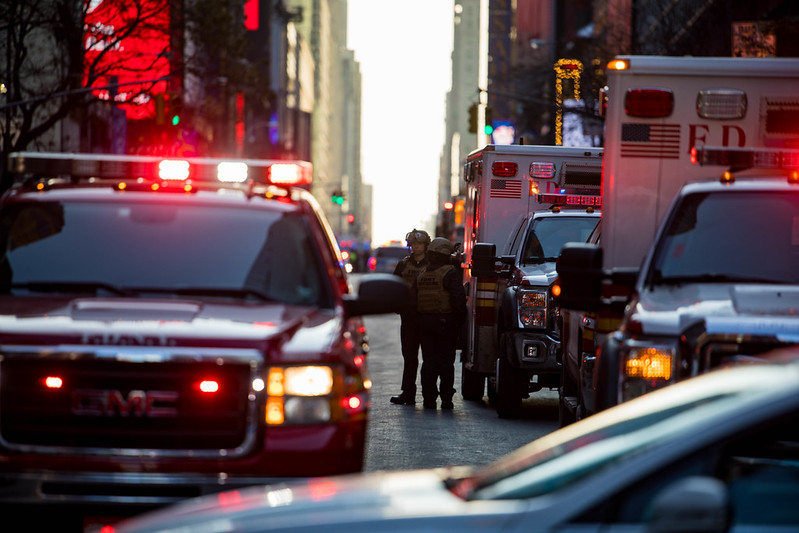 fdny personnel talking amongst fire trucks