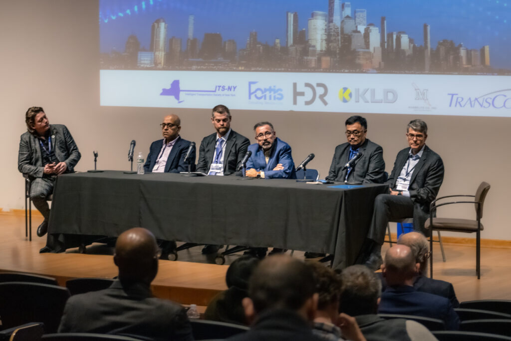 panel on stage at the symposium