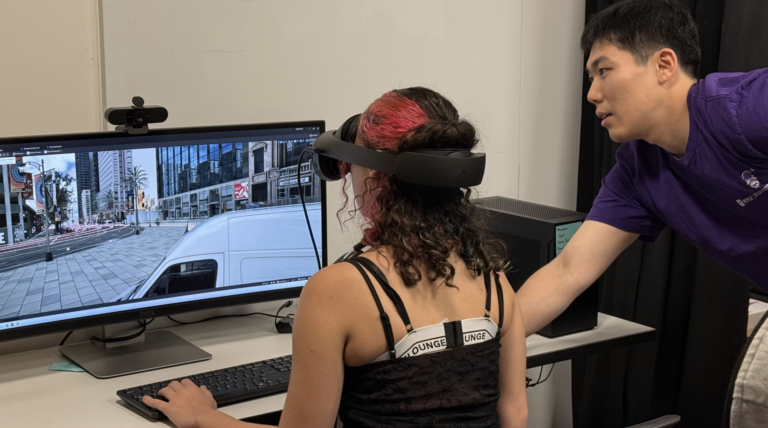 Shuo Zhang showing a student how to use VR at STEM day