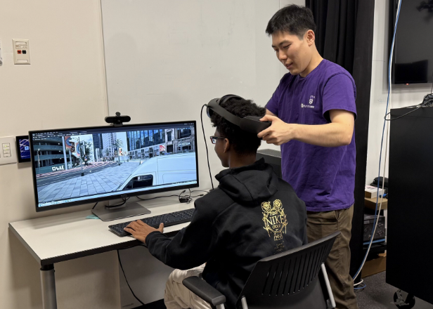 Shuo Zhang showing a student how to use VR at STEM day