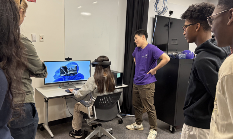 Shuo Zhang showing a student how to use VR at STEM day