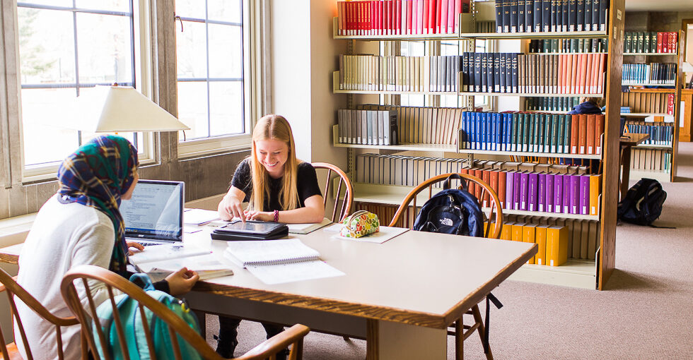 2 students at a table in a library