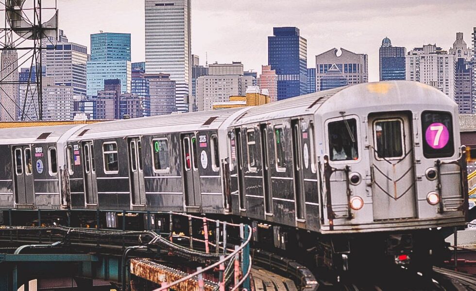 7 train on a track with cityscape behind it
