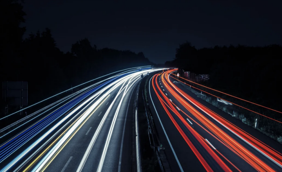 photo of a highway at night with car lights